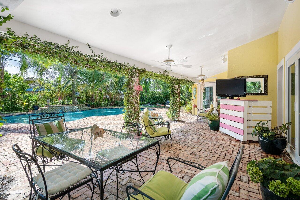 243 Florenada Terrace Boca Raton, FL 33486 - Photo 38 of 48 a view of a patio with couches chairs potted plants and a palm tree