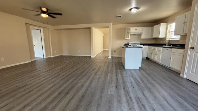 a kitchen with wooden floors and white cabinets