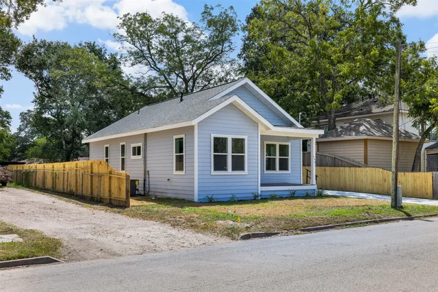 a front view of house with yard and trees in the background