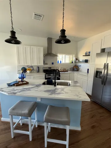 a kitchen with a dining table chairs stainless steel appliances and cabinets