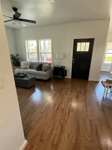 a living room with furniture and a wooden floor