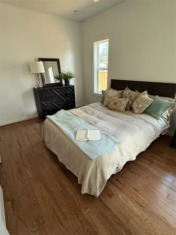 a bedroom with a bed and wooden floor