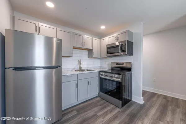 a kitchen with stainless steel appliances a refrigerator sink and microwave
