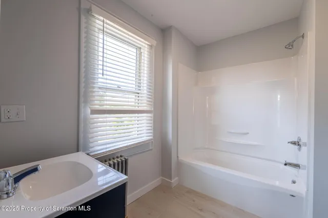 a bathroom with a bathtub and a window