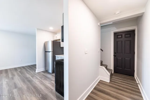 a view of a hallway with wooden floor and staircase