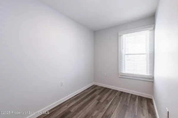 a view of a room with wooden floor and windows