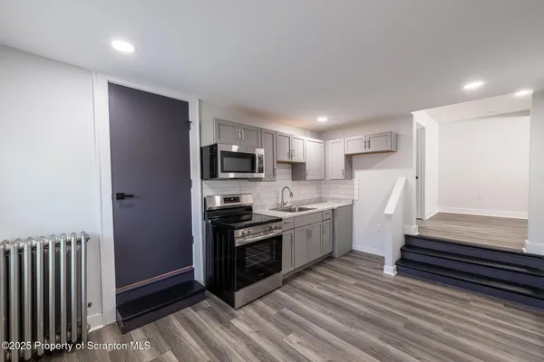 a kitchen with stainless steel appliances a refrigerator and a stove top oven