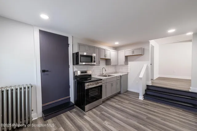 a kitchen with stainless steel appliances a refrigerator and a stove top oven