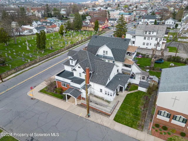 an aerial view of a house with a garden and lake view