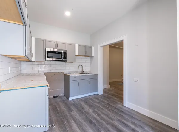a kitchen with sink a microwave and cabinets