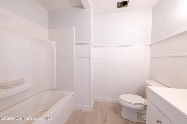 a white toilet sitting next to a bath tub