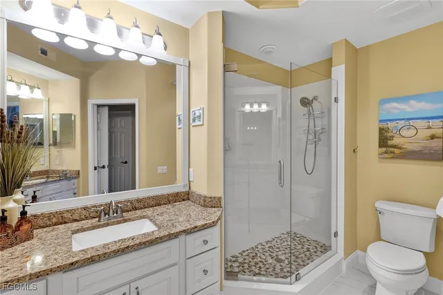 a bathroom with a granite countertop sink toilet and shower