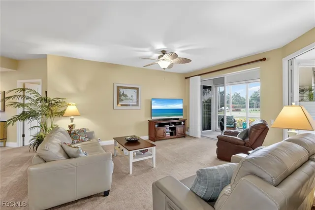 a living room with furniture a flat screen tv and a large window