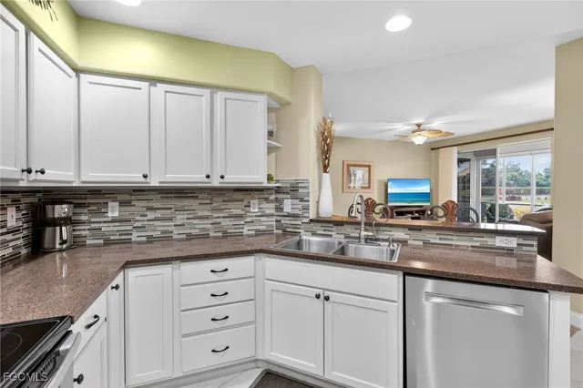 a kitchen with granite countertop white cabinets and white appliances