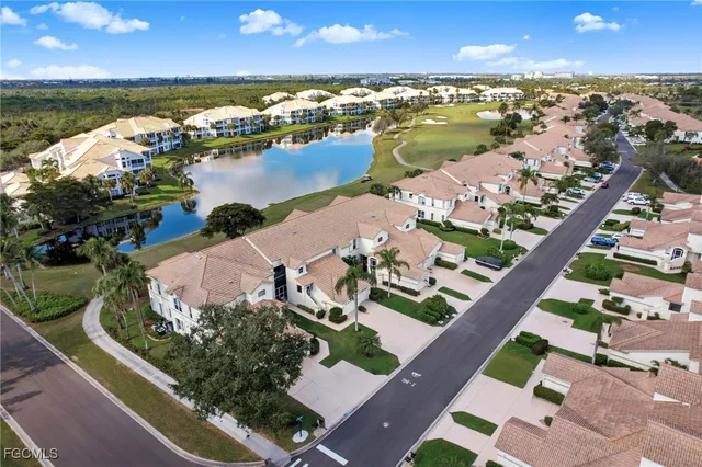 an aerial view of ocean and residential houses with outdoor space