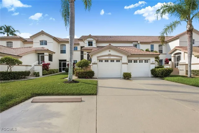 a front view of residential houses with yard and green space