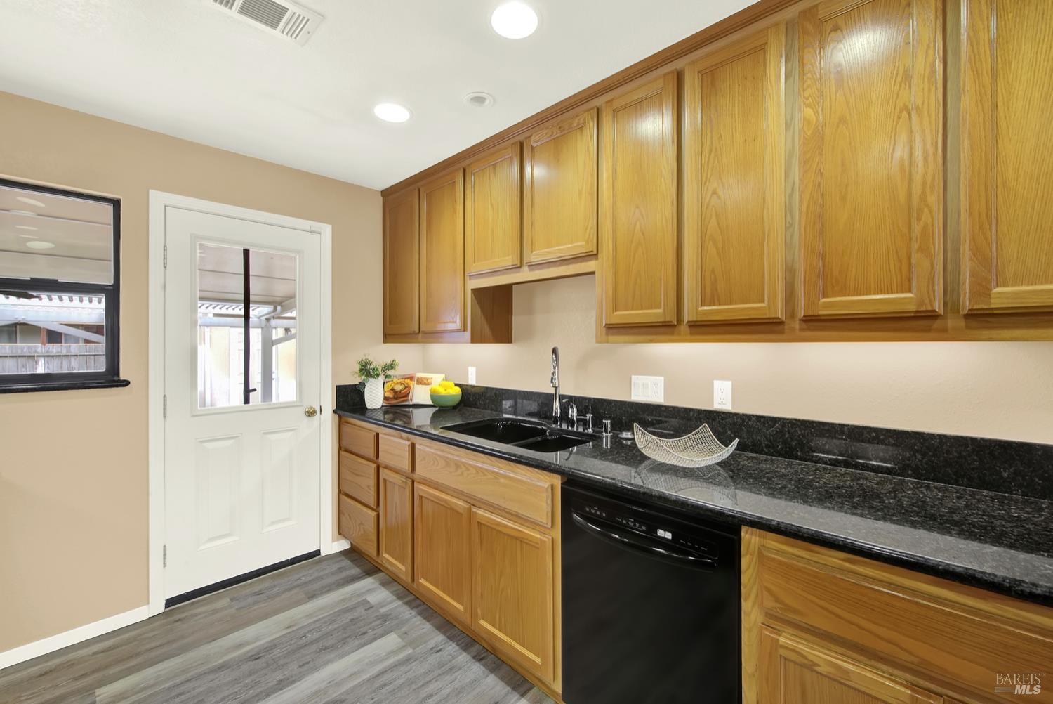 112 East Kentucky Street Fairfield, CA 94533 - Photo 26 of 70 a kitchen with stainless steel appliances granite countertop a sink a stove cabinets and wooden floor