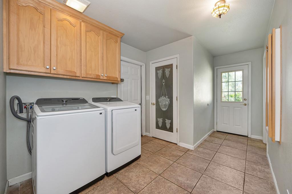 6181 Lambert Lane El Dorado, CA 95623 - Photo 40 of 68 laundry area featuring washer and dryer, cabinet space, and light tile patterned floors