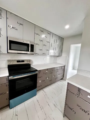 a kitchen with stainless steel appliances a stove microwave and cabinets