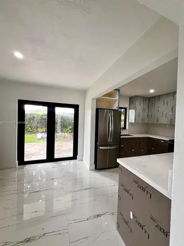 a view of a kitchen with a sink and large window