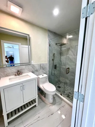 a bathroom with a sink toilet and shower