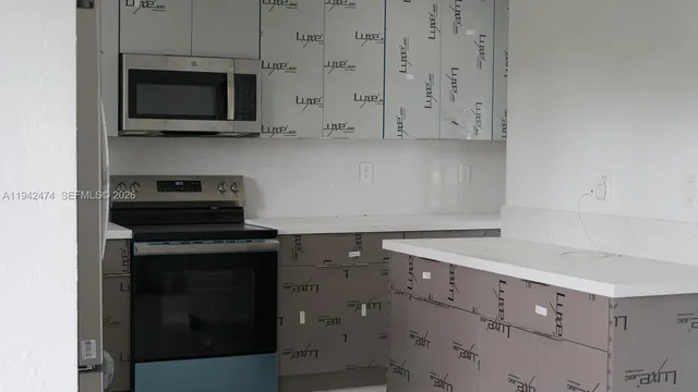 a kitchen with granite countertop white cabinets stainless steel appliances and sink