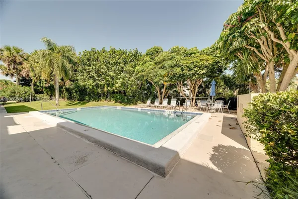 a view of yard with swimming pool and trees
