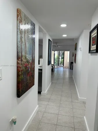 a view of a hallway with wooden floor and a living room