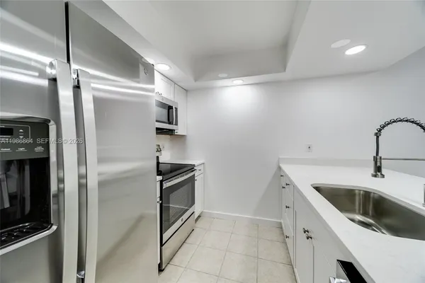 a kitchen with a refrigerator sink and cabinets