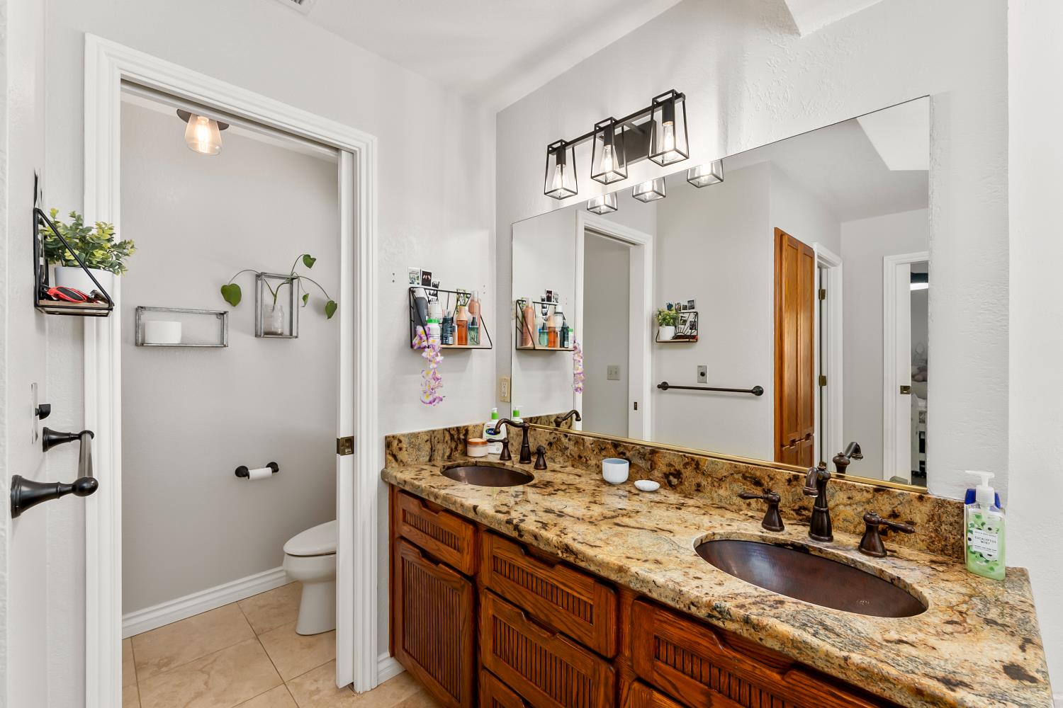 5990 Upper Ridge Way Auburn, CA 95602 - Photo 25 of 51 a bathroom with a granite countertop sink a toilet and a mirror
