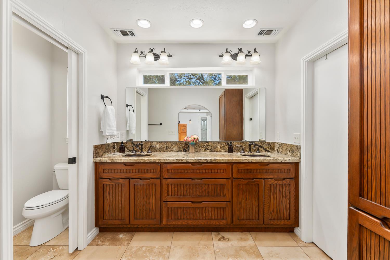 5990 Upper Ridge Way Auburn, CA 95602 - Photo 26 of 51 a bathroom with a granite countertop sink a toilet and a mirror
