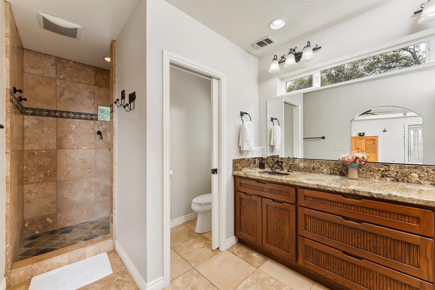 5990 Upper Ridge Way Auburn, CA 95602 - Photo 27 of 51 a bathroom with a granite countertop sink a mirror and a shower