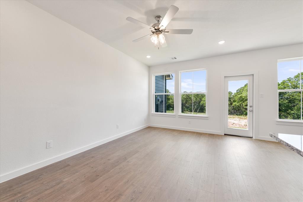 1210 Chestnut Court, Unit 1 Runaway Bay, TX 76426 - Photo 13 of 29 a view of an empty room with wooden floor and a window