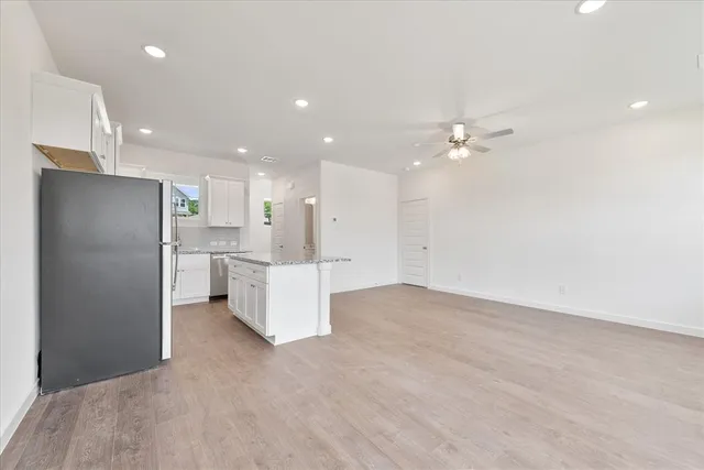 a view of kitchen with refrigerator cabinets and ceiling fan