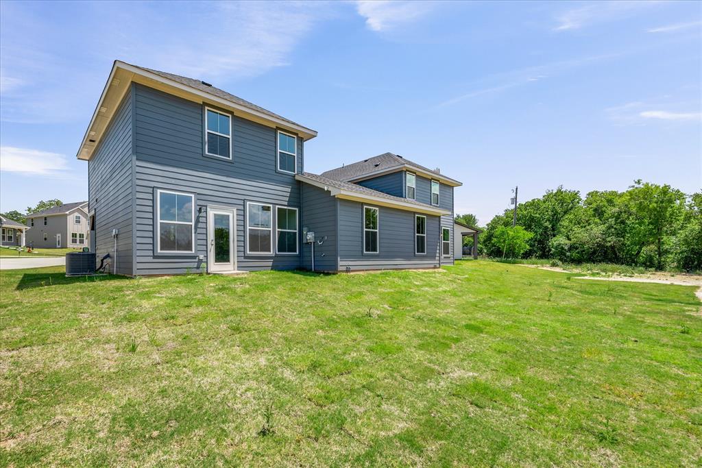 1210 Chestnut Court, Unit 1 Runaway Bay, TX 76426 - Photo 28 of 29 a front view of a house with a garden