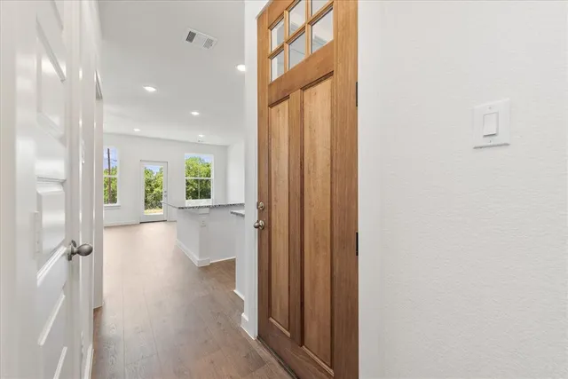 a view of a hallway with wooden floor and windows