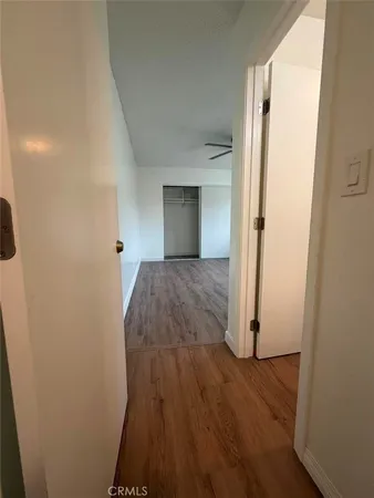 a view of a hallway with wooden floor and closet