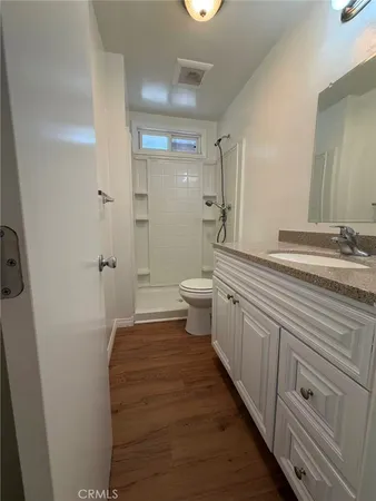 a bathroom with a sink a toilet and shower