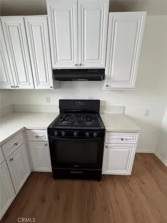 a kitchen with granite countertop white cabinets and appliances