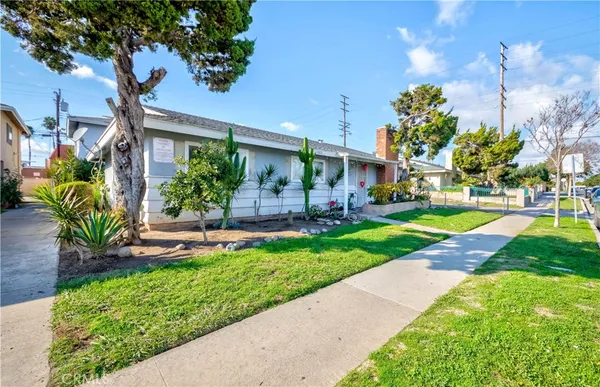 a view of a house with a yard and potted plants