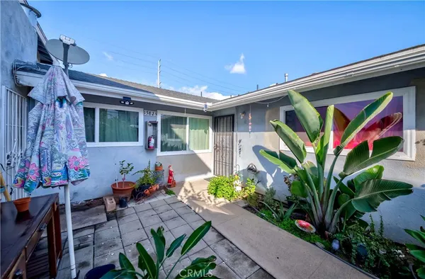 a front view of a house with lots of potted plants