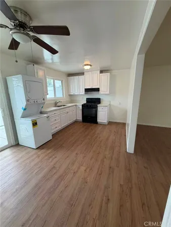 a large kitchen with a wooden floor and stainless steel appliances