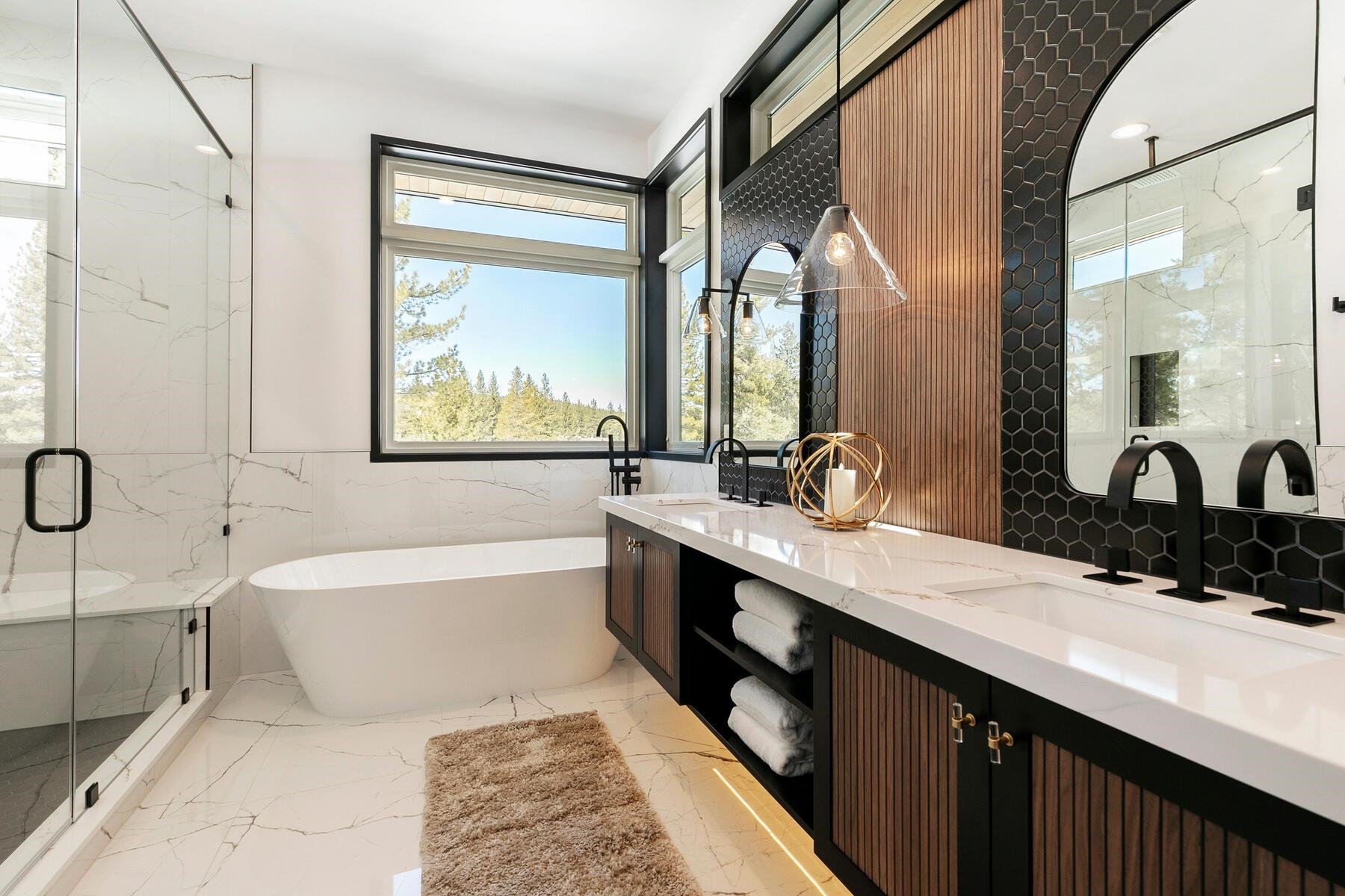 11687 Henness Road Truckee, CA 96161 - Photo 14 of 21 a bathroom with a double vanity sink a large mirror and a bathtub