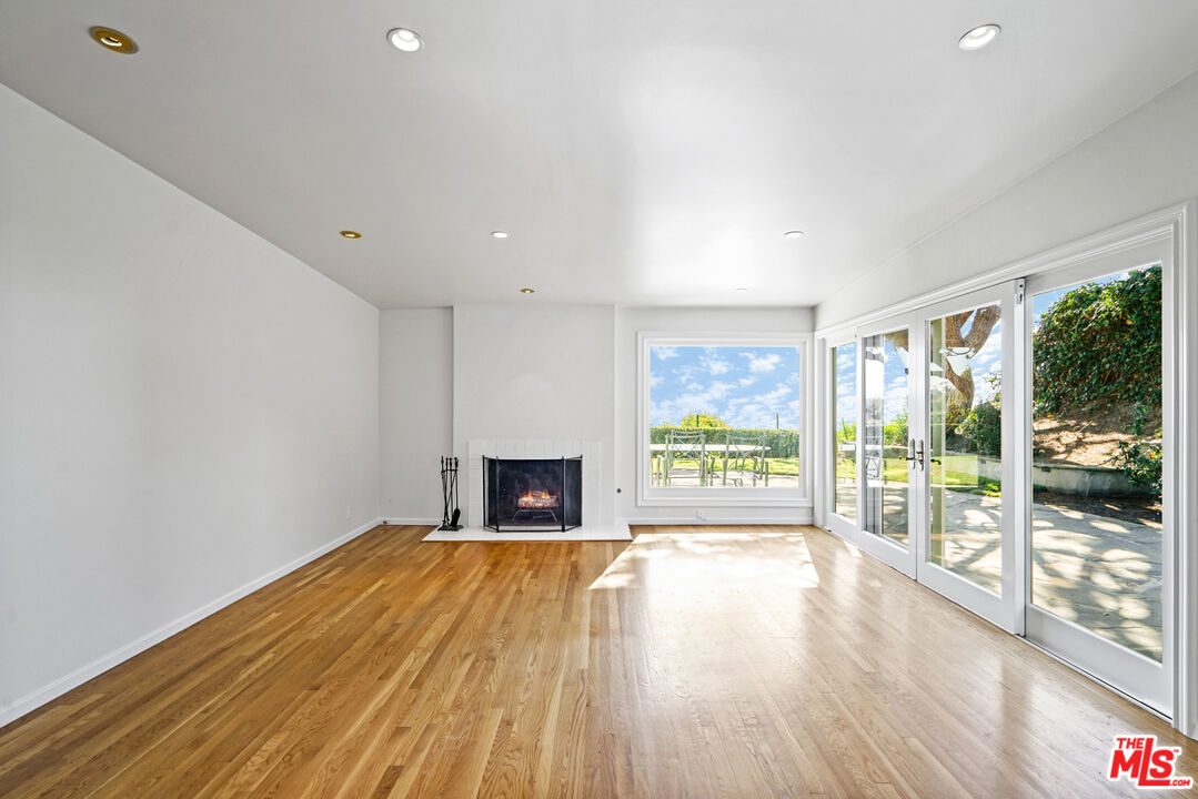 3444 Cloudcroft Drive Malibu, CA 90265 - Photo 4 of 50 a view of empty room with wooden floor and fireplace