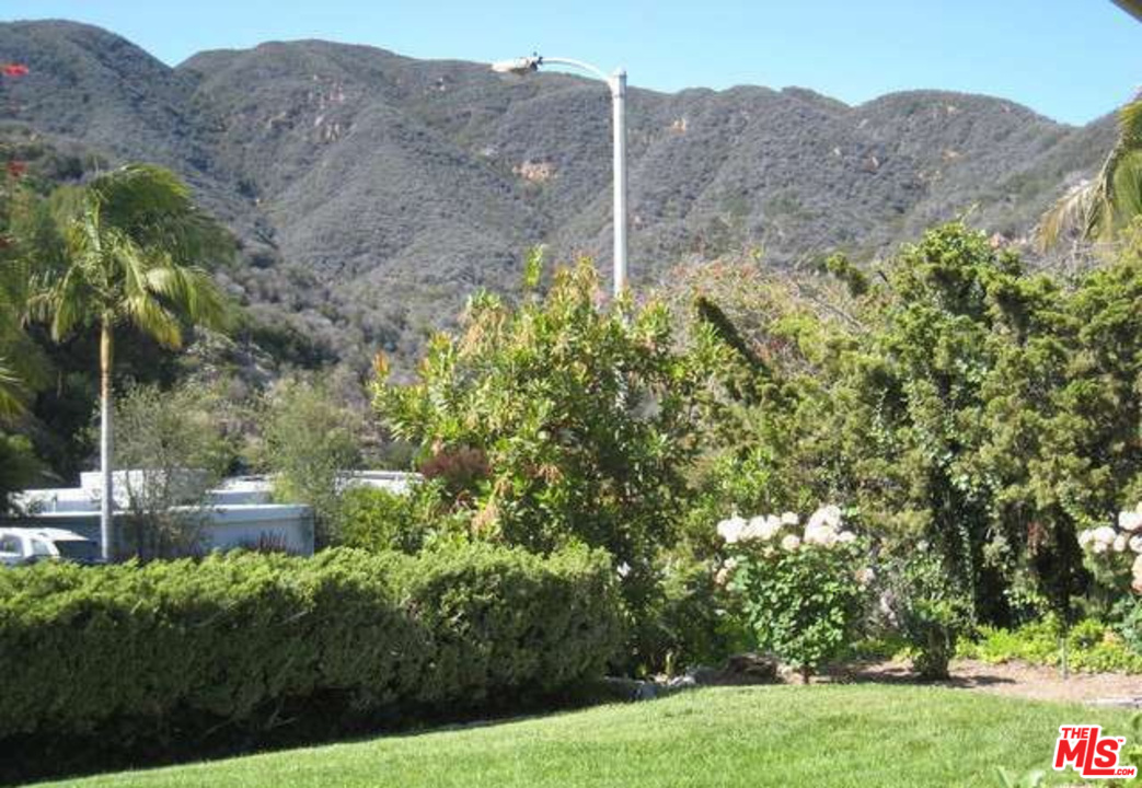 3444 Cloudcroft Drive Malibu, CA 90265 - Photo 44 of 50 a view of a lush green hillside and a building