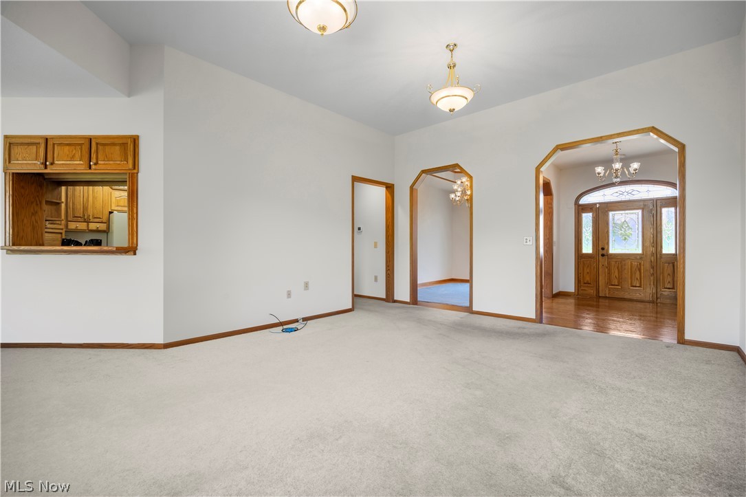51488 Peck Wadsworth Road Wellington, OH 44090 - Photo 20 of 50 Spacious living area featuring light-toned carpeting, white walls, and wood-trim baseboards