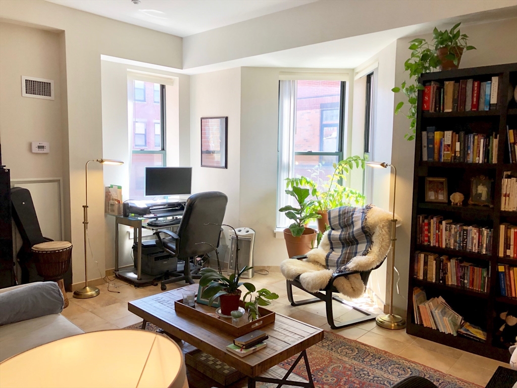 35 Fay Street, Unit 315 Boston, MA 02118 - Photo 2 of 8 a livingroom with workspace and a bookshelf