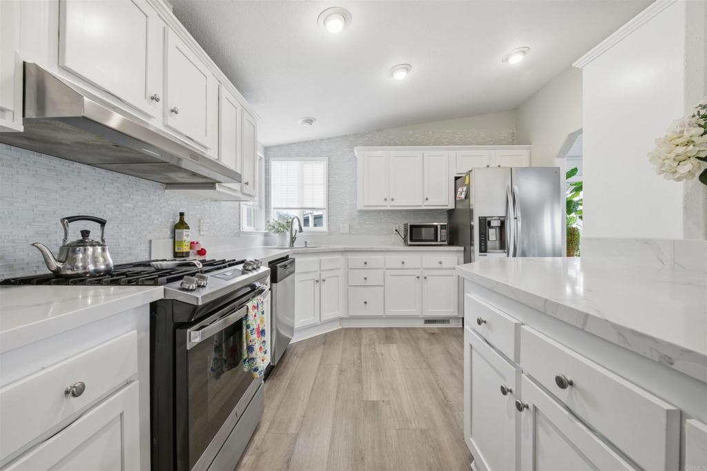 8545 Mission Gorge Road, Unit SPC #147 Santee, CA 92071 - Photo 20 of 43 a kitchen with cabinets wooden floor and stainless steel appliances