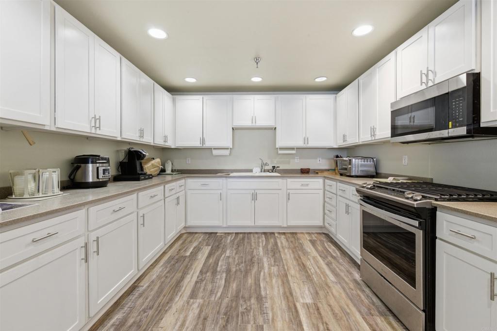 8545 Mission Gorge Road, Unit SPC #147 Santee, CA 92071 - Photo 40 of 43 a kitchen with granite countertop white cabinets and stainless steel appliances
