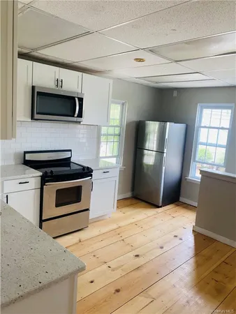 a kitchen with stainless steel appliances kitchen island granite countertop a stove a microwave and a refrigerator